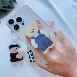 Nahaufnahme eines niedlichen Bären-Acryl-Telefongriffs, der an einem Smartphone befestigt ist.