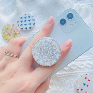 Detailweergave van een iriserende hart mandala telefoonhouder op een witte smartphone