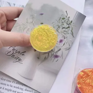 Nahaufnahme eines runden gelben irisierenden Handy-Griffs mit einer einzigartigen Knitteroptik