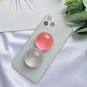 Dettaglio ravvicinato di un supporto per telefono a sfera di cristallo rosa su uno smartphone
