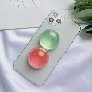 Primo piano di impugnature per telefono a sfera di cristallo rosa e verdi su smartphone