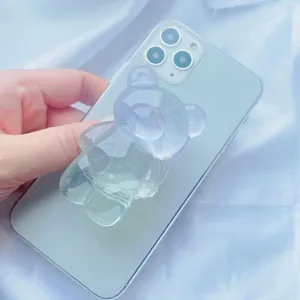Gros plan du support de téléphone ours translucide et irisé fixé à l'arrière du mobile