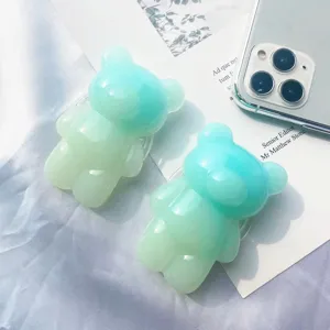 Primer plano de bonitos soportes para móvil de ositos con un elegante degradado en color verde.