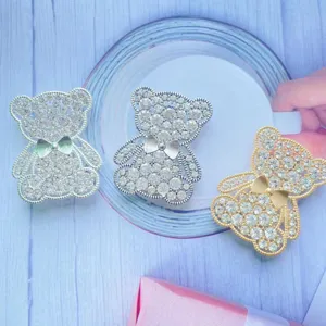 Primo piano di supporti per telefono a forma di orso con diamanti in oro e argento
