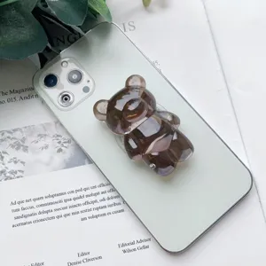 Dettaglio di un supporto per telefono a forma di orsetto grigio fumé