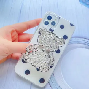Supporto per telefono a forma di orso con strass e fiocco su custodia a pois