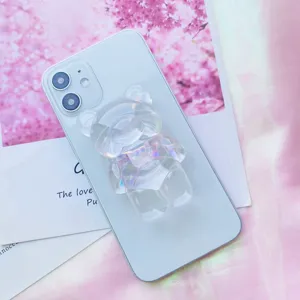 Primo piano di un supporto per telefono a forma di orso iridescente con fiocco rosa
