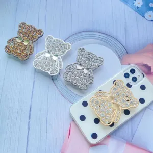 Primo piano di supporti per telefono a forma di orsetto con strass e papillon