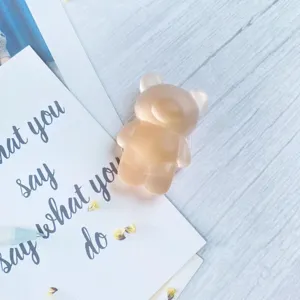 Close-up of a cute matte translucent bear-shaped phone grip on a decorative background.