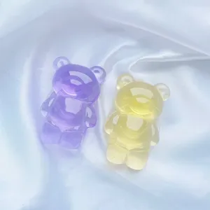 Détail de supports de téléphone translucides en forme d'ours sur de la soie blanche