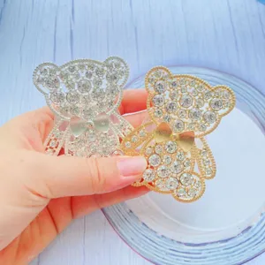 Dettaglio dei supporti per telefono a forma di orso con strass oro e argento lucido