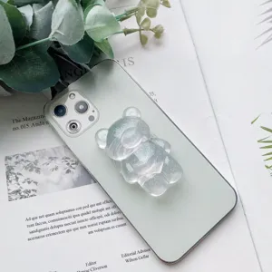 Primo piano di un supporto per telefono a forma di orso glitterato su uno smartphone verde