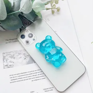 Primo piano di un simpatico supporto per telefono a forma di orsetto blu traslucido