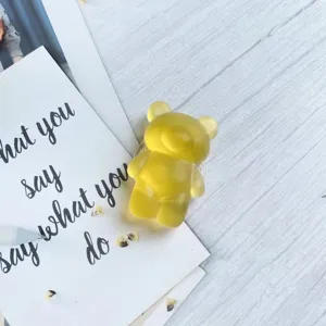 Close-up of a cute yellow gummy bear phone grip with a frosted semi-transparent finish.