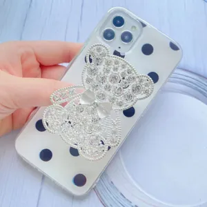 Dettaglio di un supporto per telefono a forma di orsetto con strass e fiocco argento