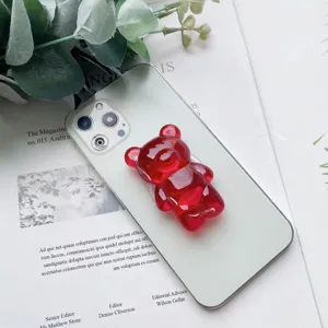 Primo piano di un supporto per telefono a forma di orsetto rosso gommoso.