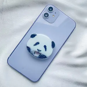 Close-up of cute panda face acrylic expandable phone socket on purple smartphone