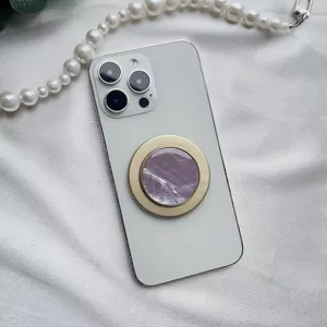 Vista dettagliata di un supporto per telefono rotondo con motivo a conchiglia viola su iPhone