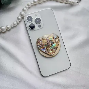 Dettaglio del supporto magnetico per telefono a cuore con texture a conchiglia colorata