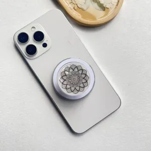 Detail der Magsafe-Handyhalterung mit holografischem Mandala-Muster auf weißem Handy
