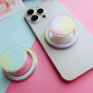 Macro shot of a pastel gradient magnetic expandable phone grip on a white smartphone