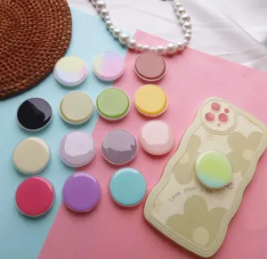 Detailopname van kleurrijke ronde glanzende telefoonhouders in diverse pasteltinten