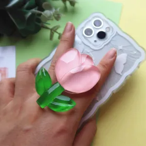 Macro view showing high-transparency pink resin flower phone grip on a smartphone