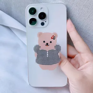Süßer koreanischer Acryl-Handygriff mit Comic-Bär auf weißem Smartphone, Standfuß