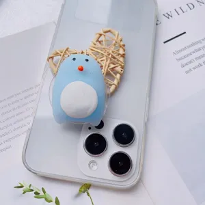 Close-up macro view of cute blue penguin squishy phone grip on transparent phone case