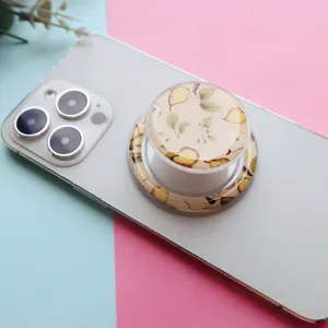 Detailed macro view of a vintage pear pattern folding phone grip on a white smartphone
