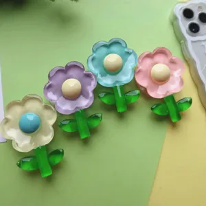 Detailed view of four colorful transparent epoxy resin flower-shaped expanding phone grips