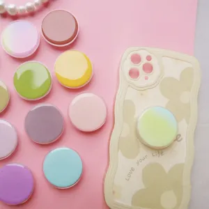 Detailopname van ronde popsocket-houders in macaronkleuren op een telefoonhoesje