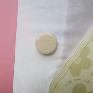 Detailopname van een glanzende beige ronde telefoonhouder met luchtkussen.