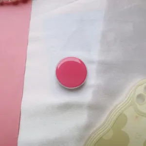 Close-up van een glanzende macaron roze ronde pop socket telefoonhouder met druppelafwerking