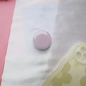 Gedetailleerde weergave van een macaron paarse ronde opvouwbare telefoonhouder op stof