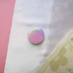 Detail van een ronde telefoonhouder met kleurverloop en een glanzende epoxyhars afwerking.