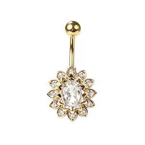 Gros plan d'un piercing de nombril tournesol doré avec zircon ovale et cristaux.