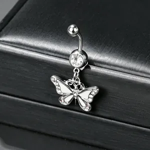 Close-up macro shot of a silver butterfly navel piercing with zircon on a jewelry box