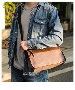 Vue détaillée du sac messager pour homme en toile et cuir, style de vie extérieur.