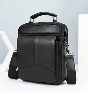 Detailed view of black genuine leather men's shoulder bag featuring durable zipper and top handle.