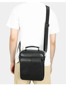 Detail view of men's genuine leather vertical cross-body shoulder bag worn on model's back.