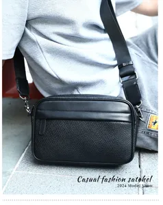 Detailed view of black genuine leather men crossbody bag with textured finish and wide strap.