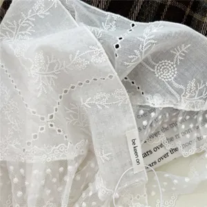 White lace embroidered fabric detail close up of vintage style decorative triangle scarf.
