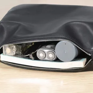Detail view of black leather bag interior showing spacious storage capacity and neat stitching.