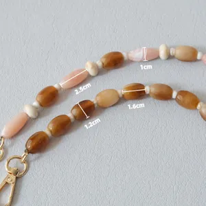Gros plan détaillé d'une chaîne en perles acryliques caramel avec mesures de taille