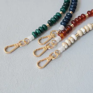 Vue détaillée de bandoulières de sac en perles acryliques avec d'élégants fermoirs dorés