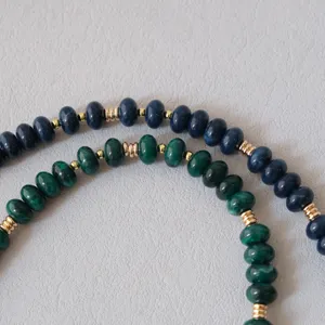 Vue macro détaillée de perles en résine bleu marine et vert avec séparateurs dorés