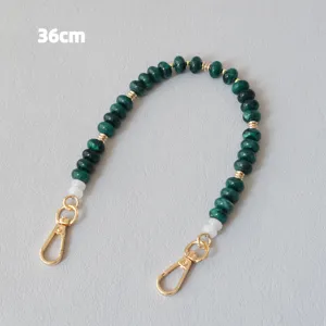 Détail d'une chaîne perlée verte de 36 cm avec fermoirs mousquetons dorés pour sacs