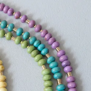 Close-up of candy-colored acrylic bead chains with golden spacers for accessories