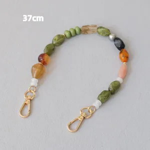 Vue détaillée d'une sangle en perles acryliques colorées de 37cm avec fermoirs dorés